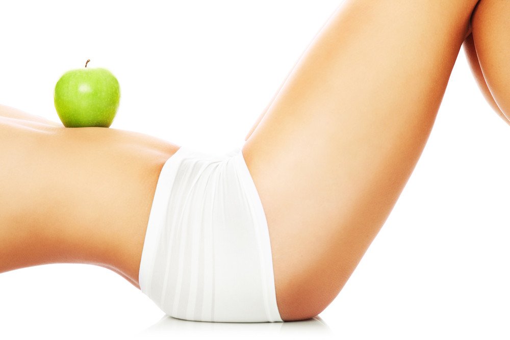 A fit woman with an apple on her tummy