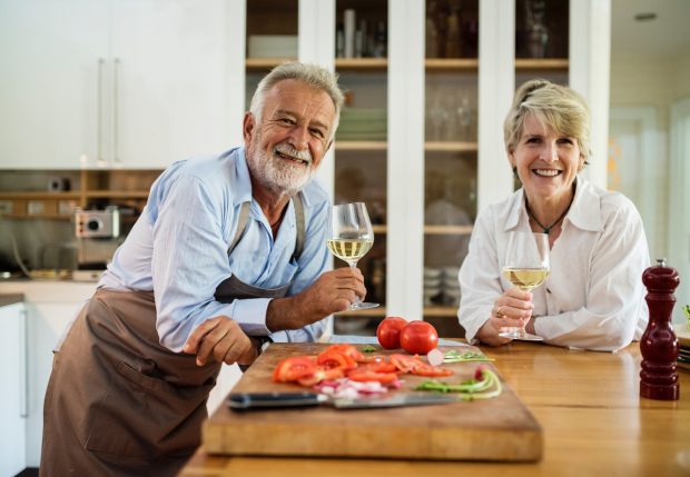 man and woman in kitchen enjoying wine