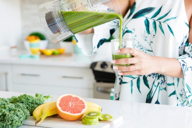 woman making green smoothie